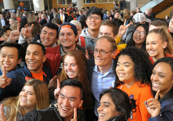 Larry Gies surrounded by students at the College's naming ceremony.